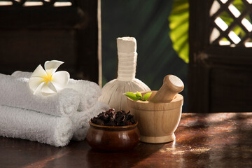 close up view of massage Compress, mortar, herb and towels  on green back. 