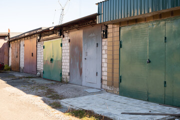 Old brick garages with metal gates. Garage cooperative for car storage. complex of old garages.