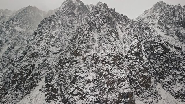 Storm, snowfall in the huge glacier of Mount Belukha, the valley of the Aktru River, the Altai Mountains. Cloudy weather, stone in the snow, storm, wildlife, winter forest, frozen mountain river in