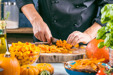 Chef cutting fresh and delicious pumkin and vegetables for cooking soup