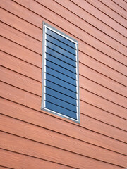 Glass louvered windows on prefabricated wooden planks for exterior decoration.