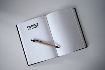 Book with pen on desk with sprint heading