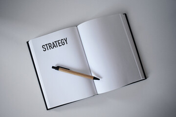 Book with pen on desk with strategy heading