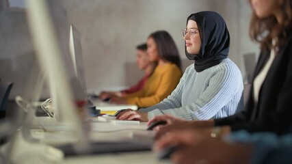 Happy Female Muslim Student Wearing a Hijab, Studying in Modern University with Diverse Multiethnic Classmates. She Asks Scholar a Question in College Room. Learning Programming or Computer Science.