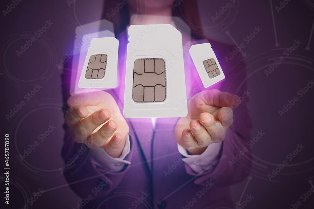 Wall mural Woman demonstrating SIM cards of different sizes on color background, closeup