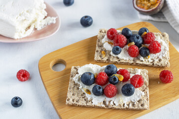 Healthy breakfast. Sandwiches made of crispy bread with cottage cheese, raspberries, blueberries and passion fruit. Healthy Eating. Slimming. A healthy snack.