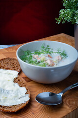 Traditional Finnish cuisine: Bowl of creamy salmon soup with dill topping. Two pieces of rye bread on the side.