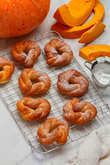 Freshly baked homemade sweet pumpkin buns with cinnamon and powdered sugar. Pumpkin pastries. Healthy autumn dessert. Halloween. Thanksgiving day. Marble background. Selective focus, top view