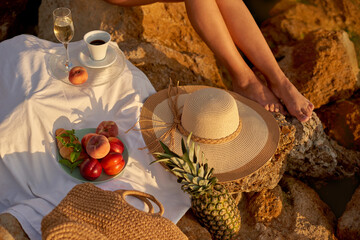 glass champagne and coffee cup in sunny morning on shore.picnic on rocky beach in summer