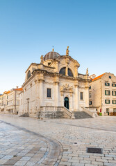 Square at St Blaise Church and people at Stradun Street in the Old city of Dubrovnik, Croatia. Summer morning with soft light.