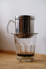 Making coffee in a Vietnamese phin with condensed milk in a glass