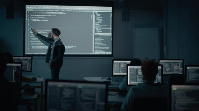 Teacher Giving Computer Science Lecture to Diverse Multiethnic Group of Female and Male Students in Dark College Room. Projecting Slideshow with Programming Code. Explaining Information Technology.