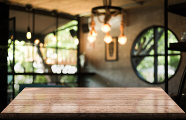 Empty wooden table top with lights bokeh on blur restaurant background.