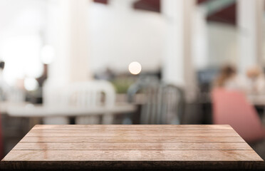 Empty wooden table top with lights bokeh on blur restaurant background.