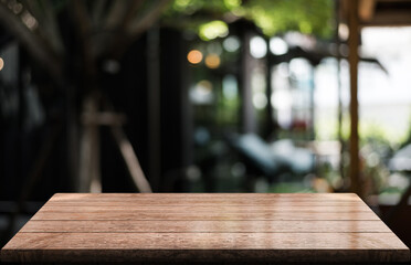 Empty wooden table top with lights bokeh on blur restaurant background.