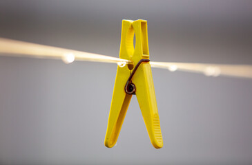 A plastic clothespin hangs on a clothesline