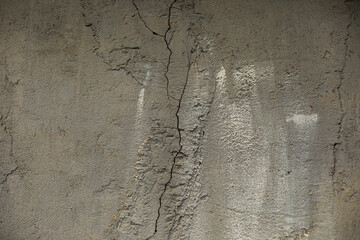 Cracked cement. Concrete wall without treatment. Surface details in cracks.