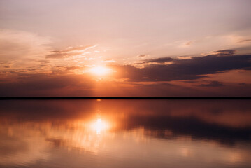Fototapeta na wymiar sunset on the shore of a pink lake