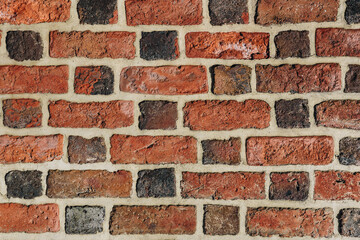 Textured red brick wall background or backdrop, rectangular red terracotta bricks laid out as pattern, architectural structure for old rough building