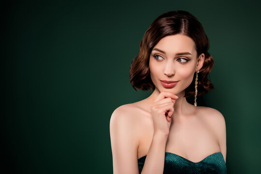 Portrait of smiling dreamy young female look copyspace thinking enjoy party isolated on green color background