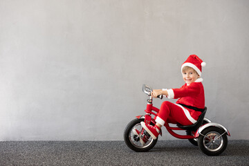 Happy child riding bike. Christmas holiday concept