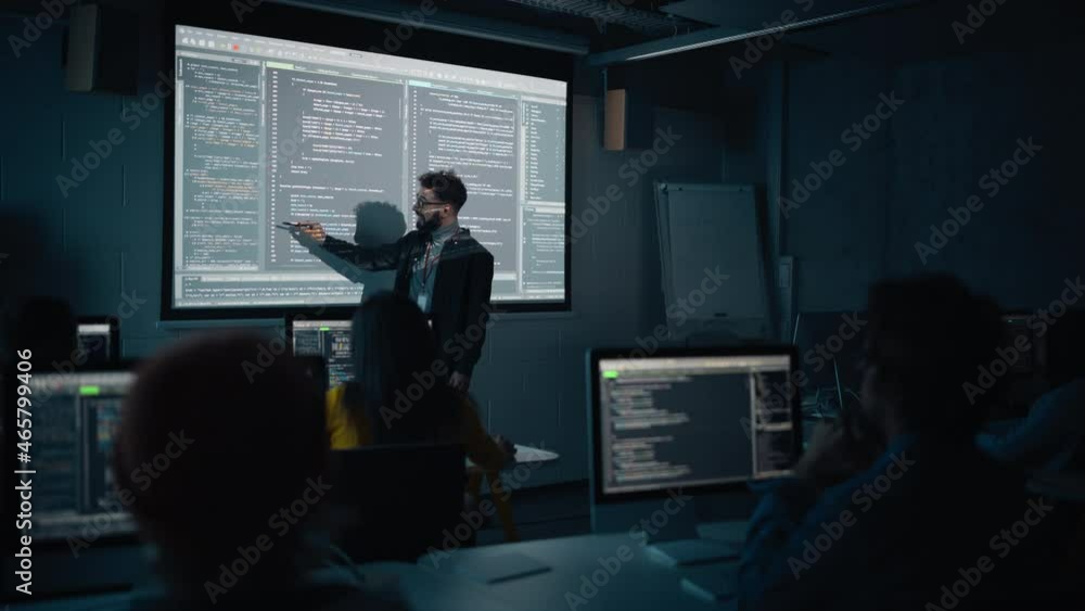 Leinwandbilder Teacher Giving Computer Science Lecture to Diverse Multiethnic Group of Female and Male Students in Dark College Room. Projecting Slideshow with Programming Code. Explaining Information Technology.