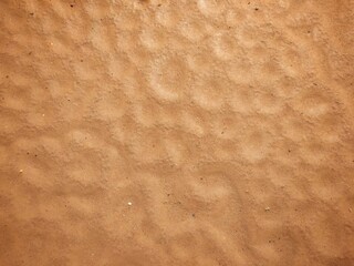 The red sand pattern looks like a hole.  Caused by natural raindrops, used as a background, wallpaper and design.