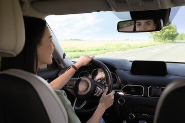 Beautiful young woman driving her modern car