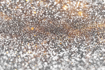 Silver and golden sparkling glitter bokeh background, christmas abstract defocused texture. Holiday lights