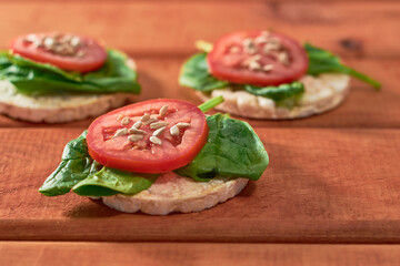Rice cakes with Spinach and tomatoes on top. Healthy food.
