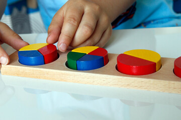 Montessori educational material for mathematic; child playing with wooden toys