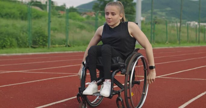 A female person with disabilities riding a wheelchair on a training track