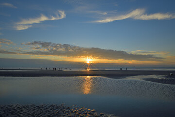 Menschen am Strand zum Sonnenuntergang