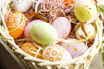 Colorful Easter eggs with ornate in decorative nest basket.