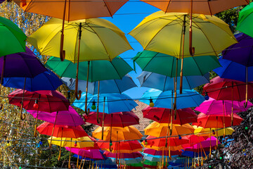 Fototapeta na wymiar many colorful umbrellas hanging in the park