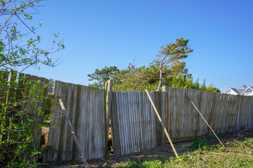 Falling down and damaged wooden fence