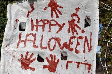 the words Happy Halloween with red handprints on a banner