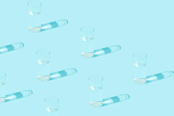 Pattern glass of water on blue background. Sunny day shadow. Space for text.