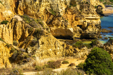 low tide, rocks and cliff to the beach Praia do Camilo, in Lagos, Algarve, Portugal