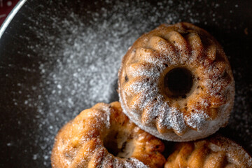 Sweet cakes sugar on top, from above, on black background
