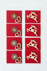 christmas decorations featuring wooden raindeer cut outs with stars, hearts, and starbursts on red paper squares