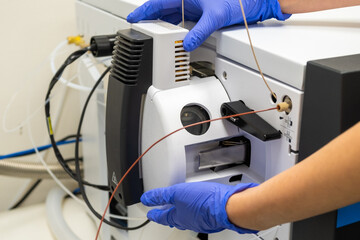 Chemist opening ion source of mass spectrometer for cleaning. Liquid chromatography with mass...