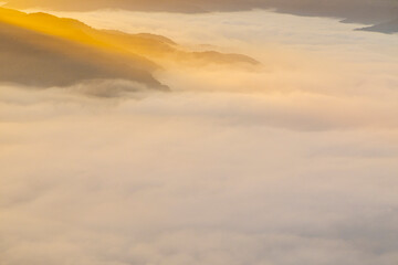 Fototapeta na wymiar Vista aérea de un rayo de sol entrando en diagonal en un paisaje con niebla al amanecer
