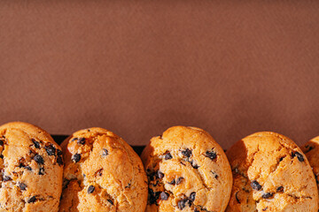 chocolate chip cookies close-up on brown background