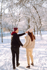 Fototapeta na wymiar Love story young couple in winter. Happy couple walking and having fun at nature. Holidays, season, love and leisure concept.