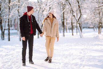 Love story young couple in winter. Happy couple walking and having fun at nature. Holidays, season, love and leisure concept.