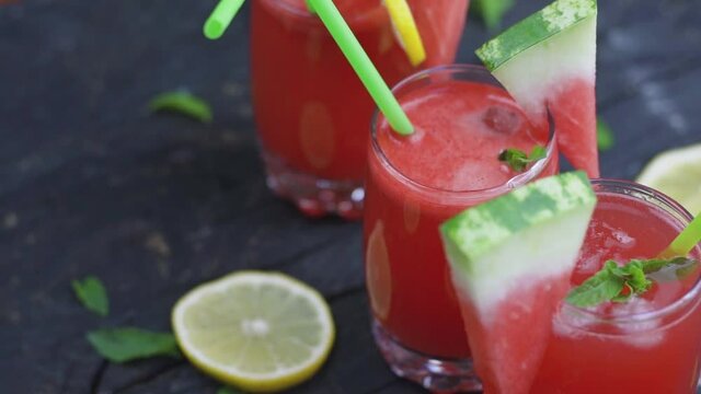 Fresh watermelon smoothie in a glass with sliced of watermelon and ice cubes. Slow motion video