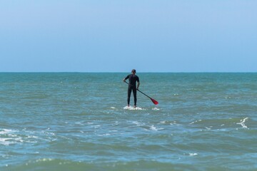 Man practicing Stand up paddle in the sea