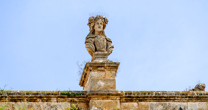 Bust on Palazzo del Sedile with pigeon defense in Bari, Italy