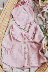 Knitted kids clothes and accessories for knitting. Needlework and knitting. Hobbies and creativity. Knit for children. Handmade Pink dress and cap
